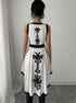 Back view of asymmetrical peplum top with black and white floral embroidery