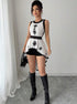Model styling peplum top with shorts and knee-high boots indoors
