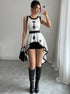 Woman wearing sleeveless embroidered peplum top with high-low hem and boots