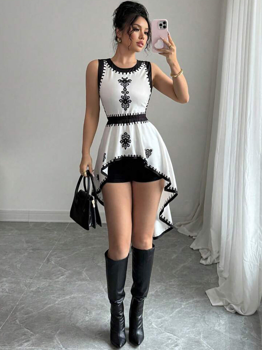 Woman wearing sleeveless embroidered peplum top with high-low hem and boots