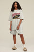 Woman facing forward wearing light grey phonograph tee.
