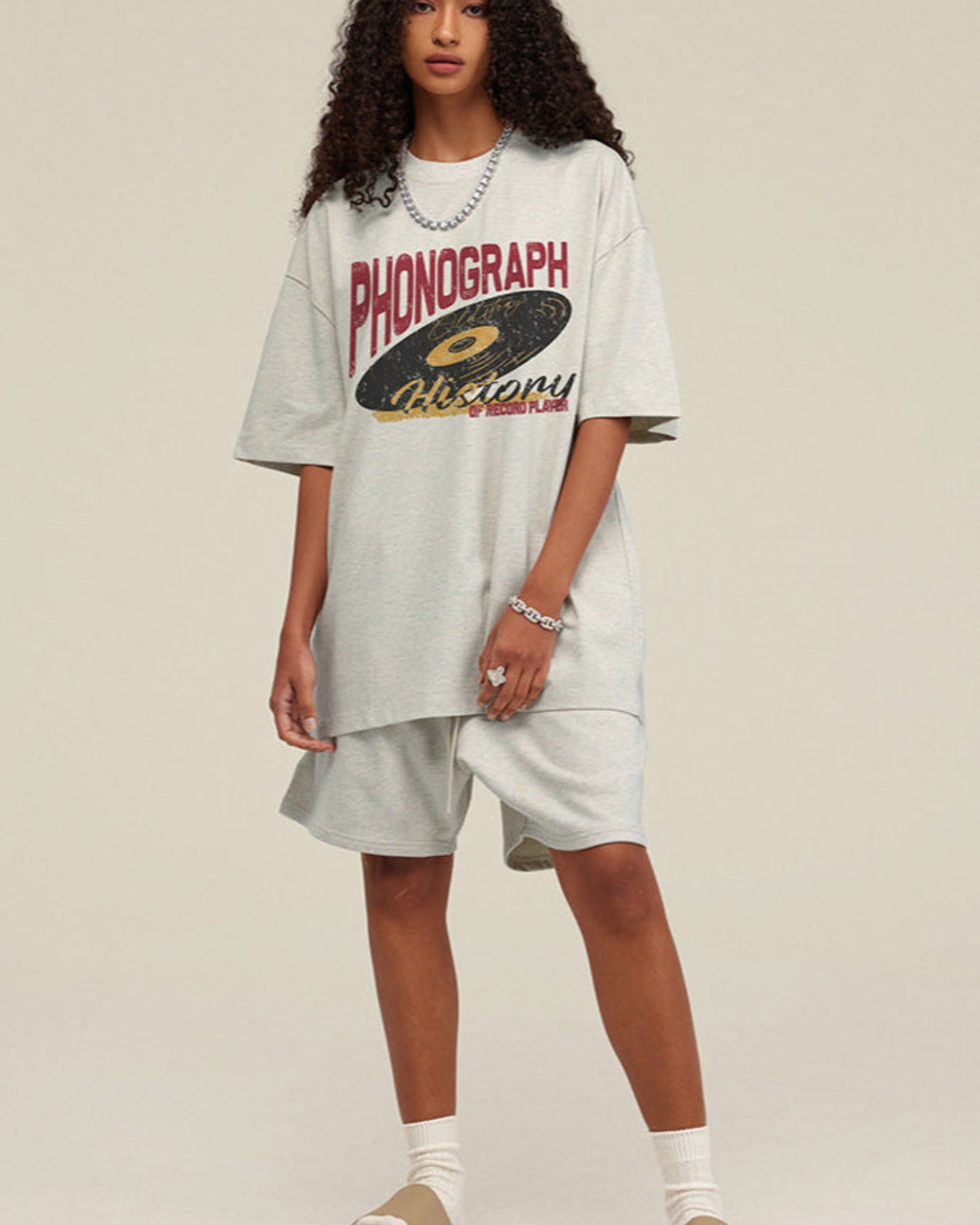 Woman facing forward wearing light grey phonograph tee.