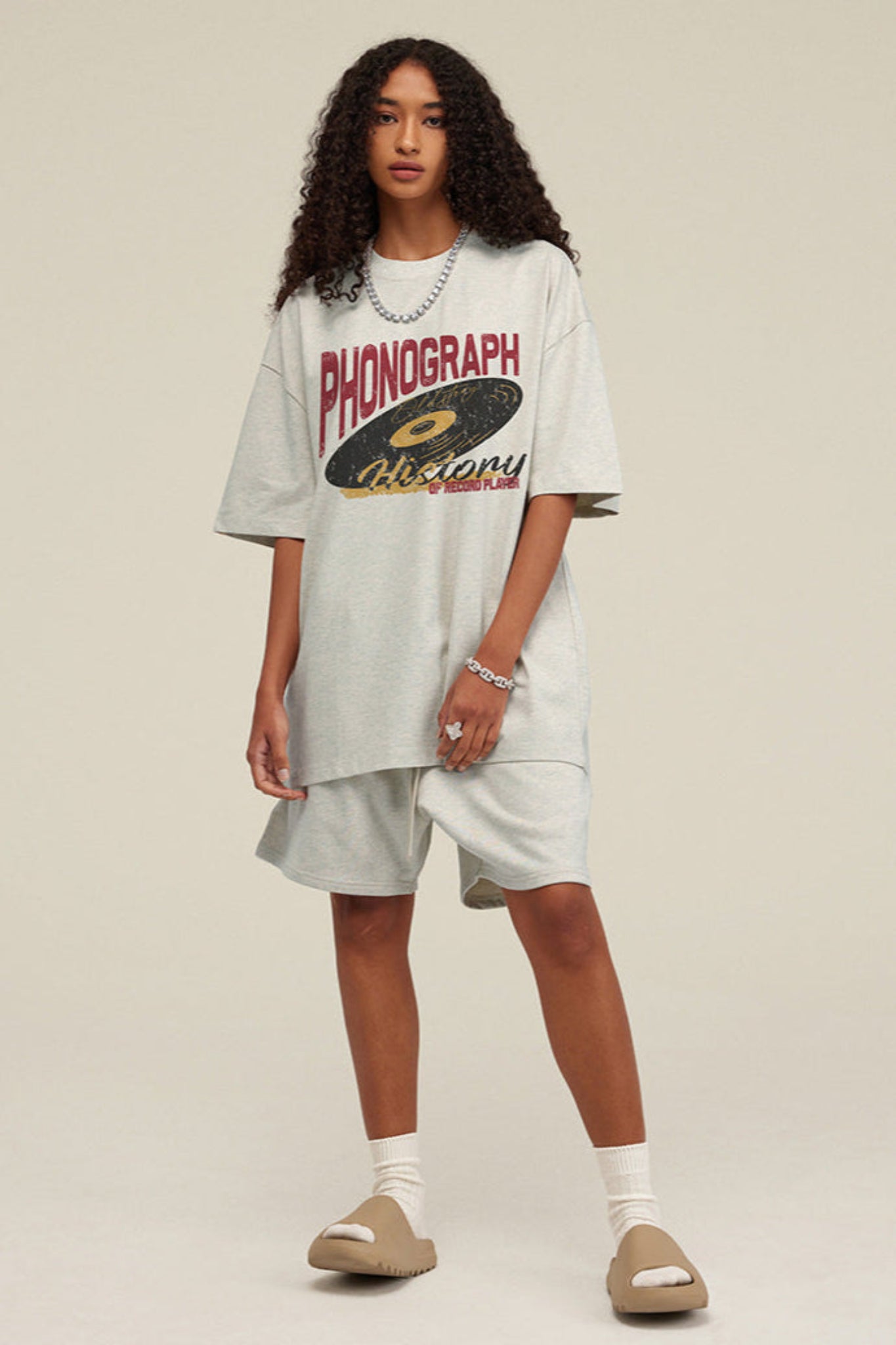 Woman facing forward wearing light grey phonograph tee.