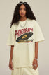 Woman in milk tea graphic tee with phonograph print and bold necklace.