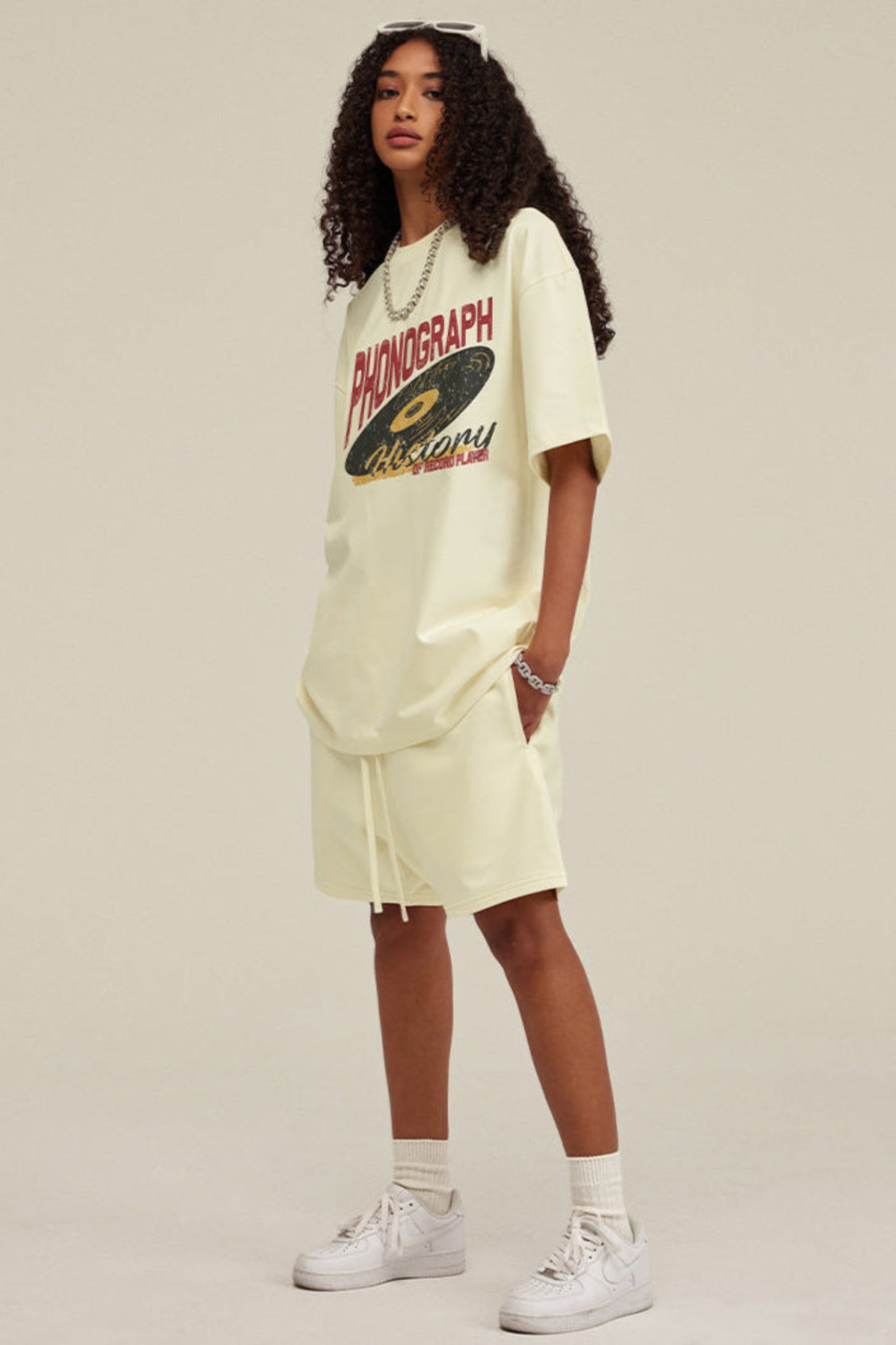 Side view of woman wearing light yellow phonograph tee.