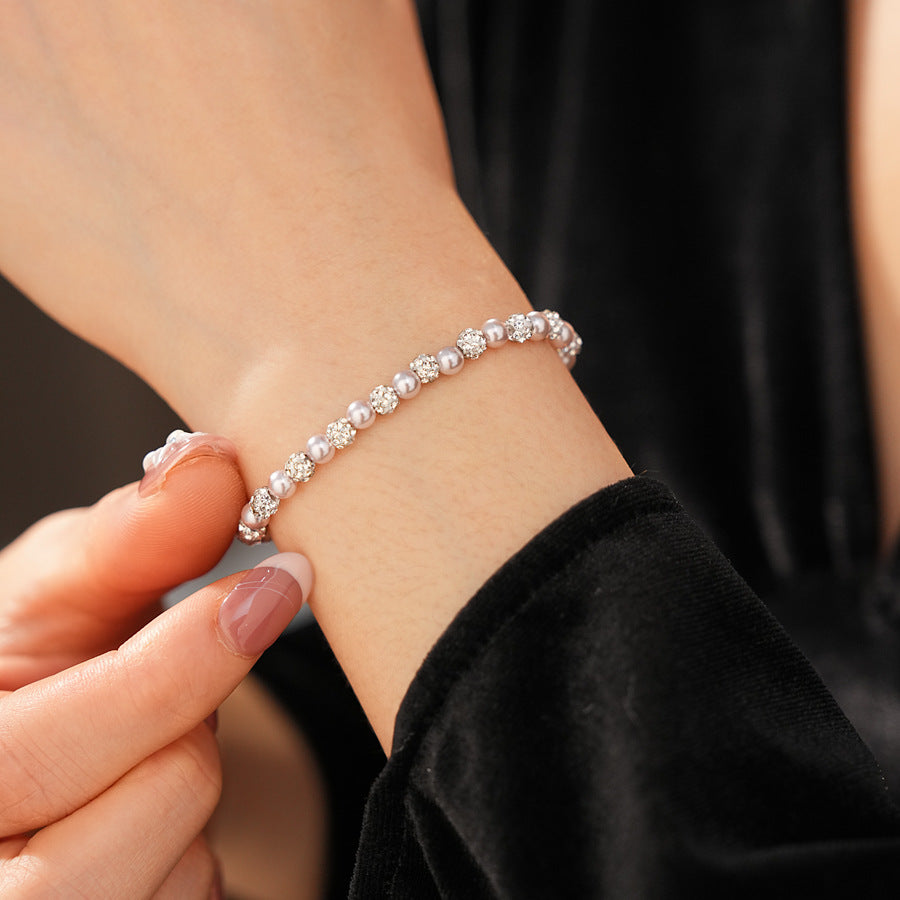 pink pearl and rhinestone bracelet viewed from the side while worn on wrist