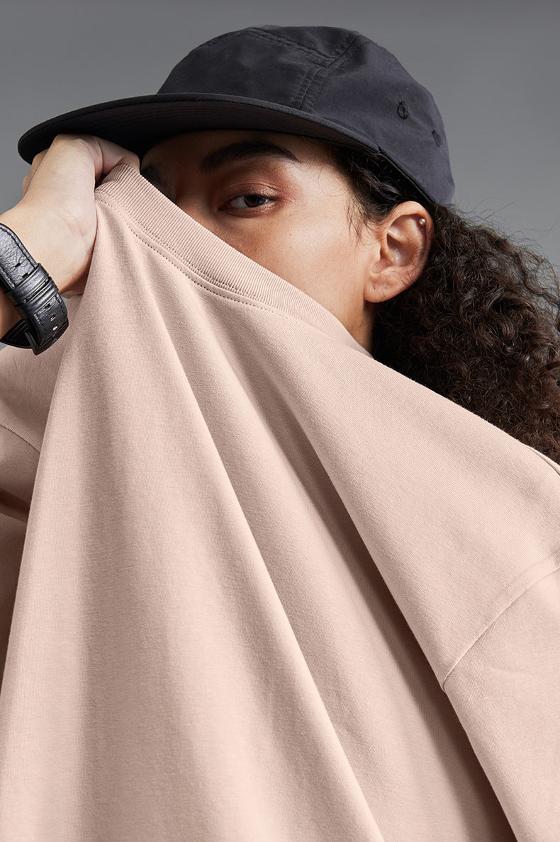 Close-up of pink tee pulled by model, showcasing soft cotton texture