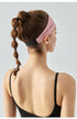 Back view of woman wearing light pink headband with black elastic band.