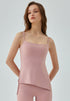 Woman in pink yoga tank top with fitted cut and side drawstrings.