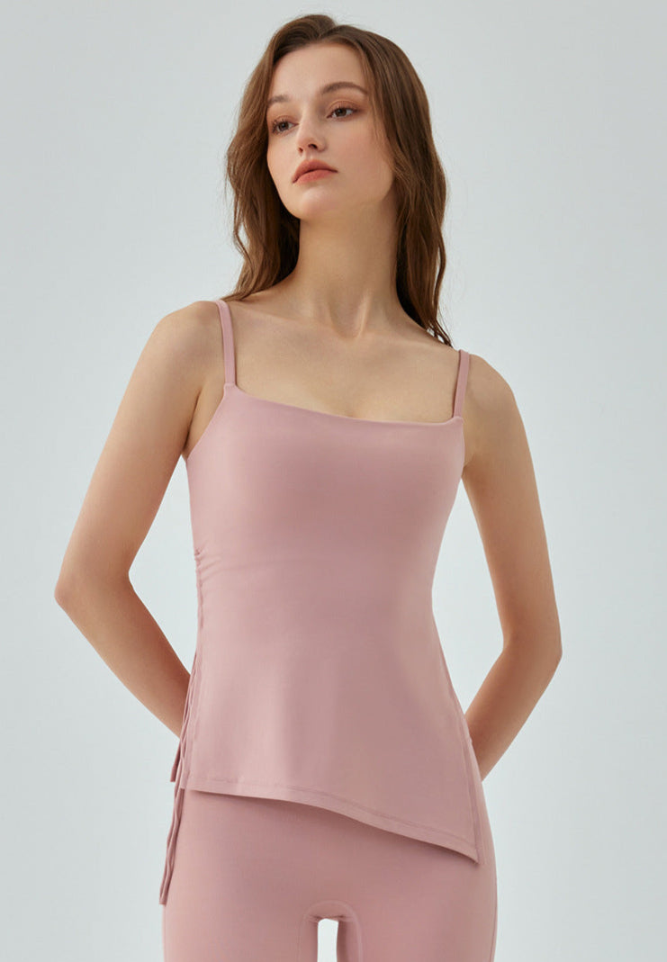 Woman in pink yoga tank top with fitted cut and side drawstrings.