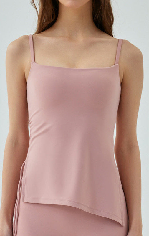 Woman in blush pink cooling tank top with asymmetrical hem and side strings.