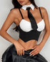 Close-up of pinstripe bustier with white collared neckline and black satin tie styled in a schoolgirl look.