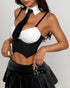 Corset top with black and white contrast design, collar detail, and edgy pleated buckle skirt.