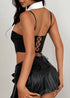 Back view of pinstripe corset top with lace-up closure, paired with black pleated mini skirt.