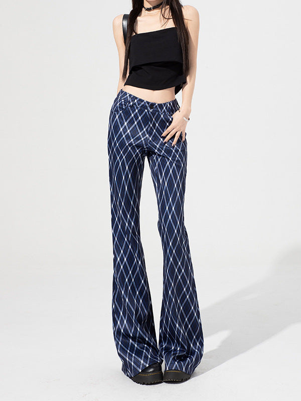 Woman posing in blue plaid bell-bottom pants styled with black top and platform shoes.