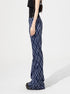Blue plaid flared pants shown from the side to highlight fit and silhouette.