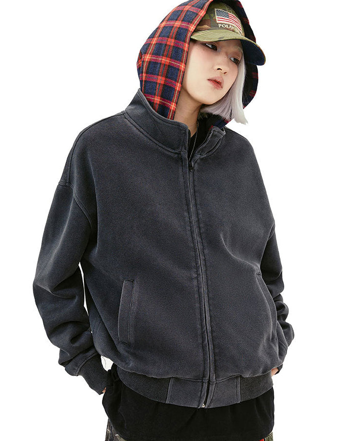 Close front view of the washed black zip-up hoodie with red plaid hood lining