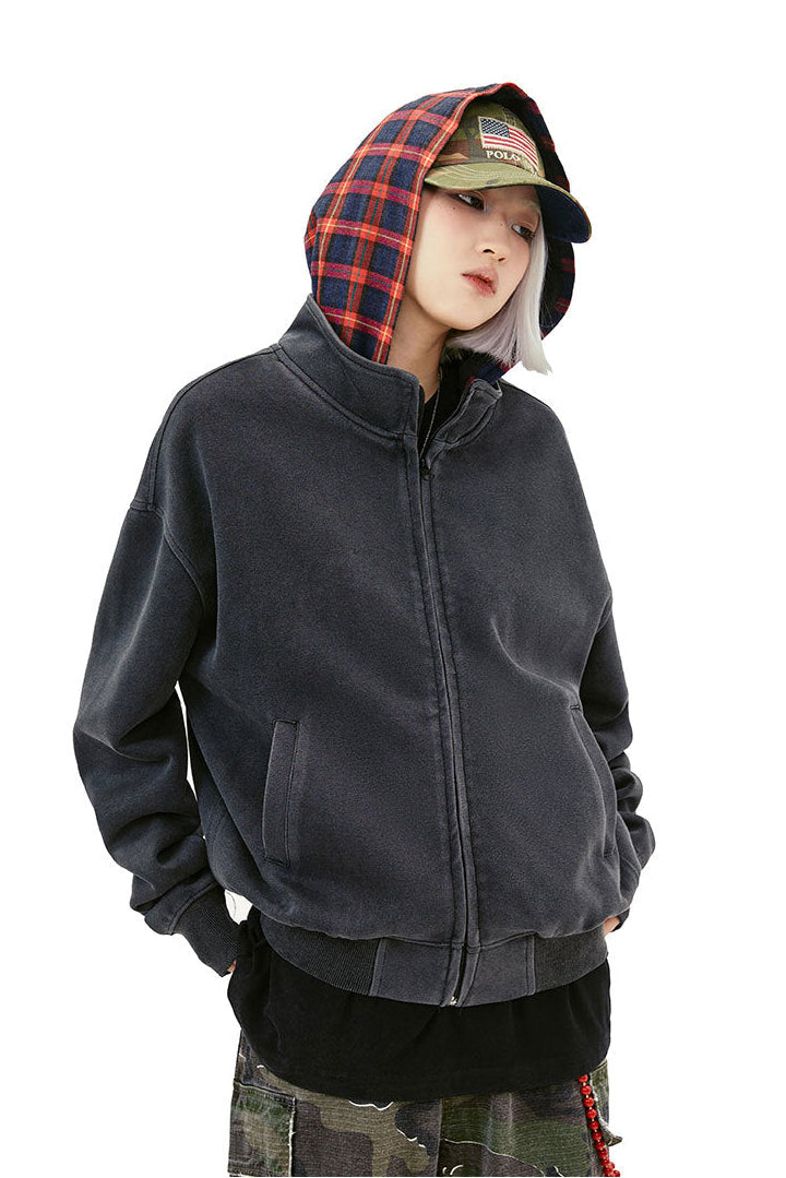 Close front view of the washed black zip-up hoodie with red plaid hood lining