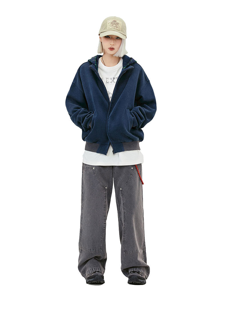 Washed navy zip-up hoodie worn open over a white graphic T-shirt