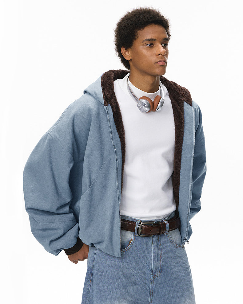 Blue plush zip jacket, relaxed fit, hands in pockets.