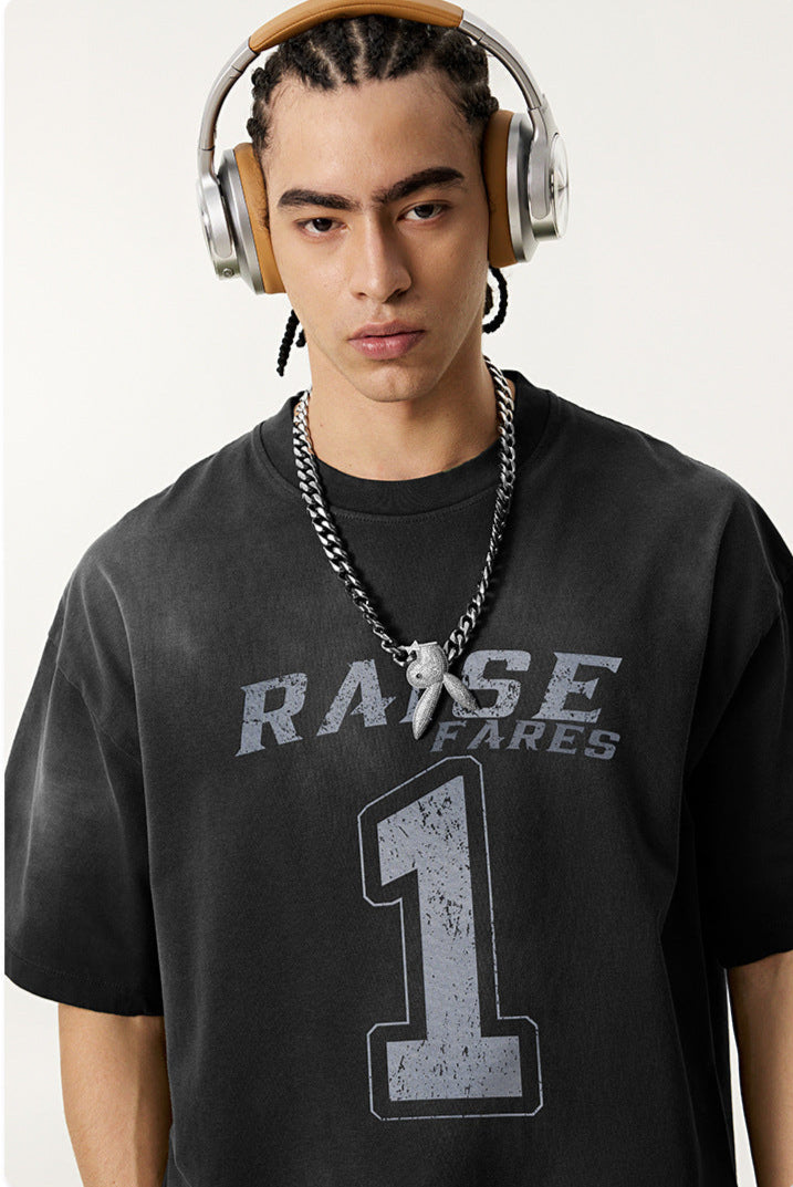 Close-up of model in black 'Raise Fares' tee with metallic headphones and chunky necklace.