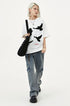 White raised dove embroidered oversized T-shirt styled with baggy cargo jeans and black platform shoes