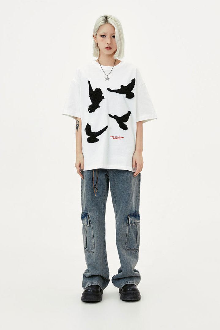 Front view of oversized white crewneck T-shirt with four contrasting raised flying dove motifs