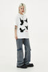 Three-quarter view of white short-sleeve T-shirt showing scattered black dove embroidery