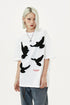 White oversized T-shirt styled with washed blue cargo jeans, star necklace, and black shoes