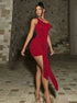 Red velvet bodycon mini dress with asymmetric neckline and dramatic knot detail front walking view.