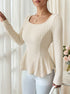 three-quarter front, cream ribbed knit top with U neck, sculpted waist and peplum hem