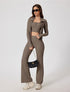 Model in taupe ribbed yoga jacket and pants, styled with black purse