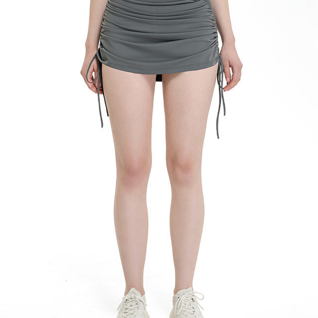 Woman wearing high-waisted ruched gray mini skirt with drawstrings.
