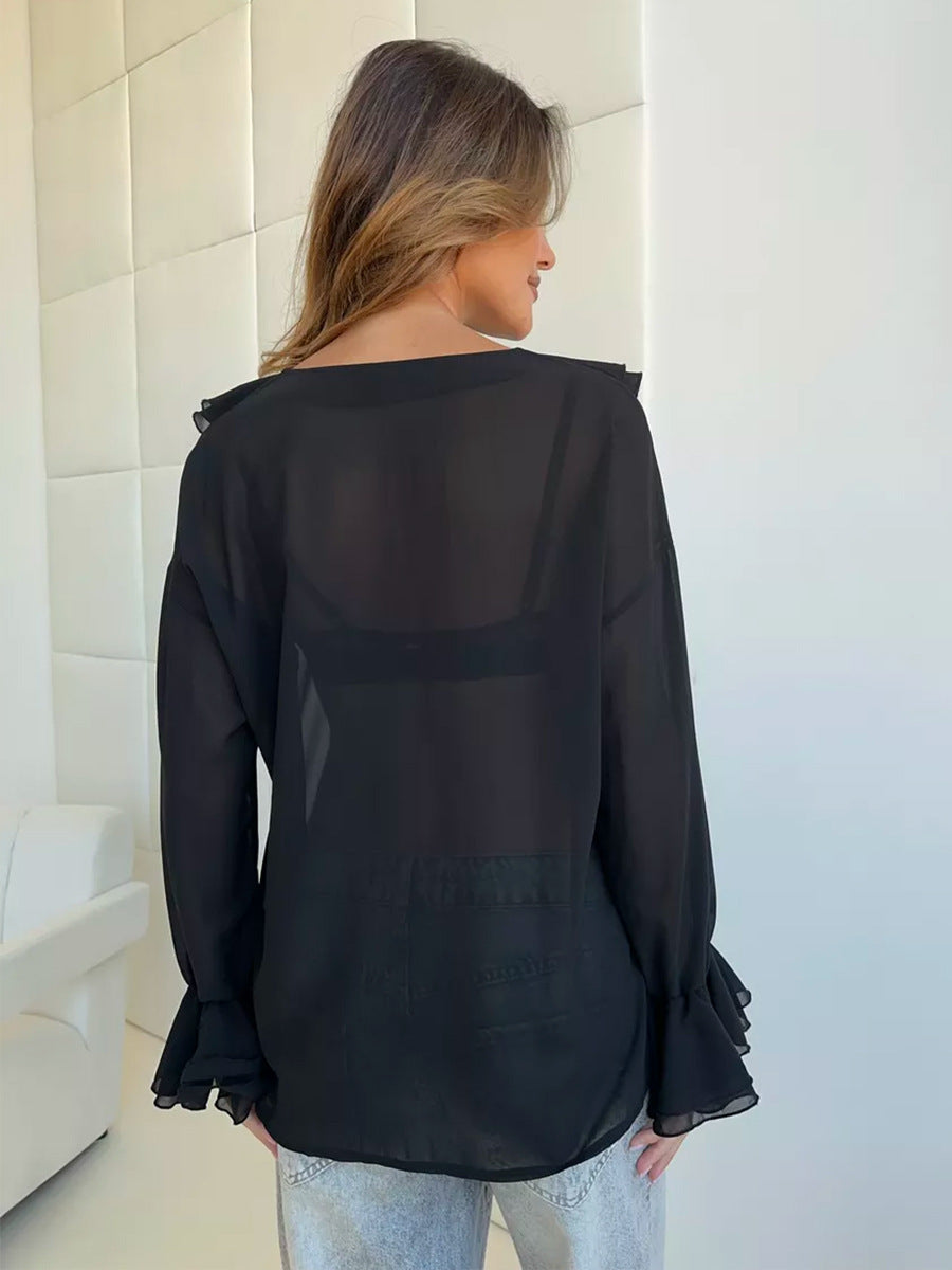 Back view of black sheer blouse with flowy sleeves and relaxed fit.