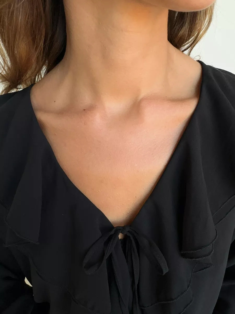 Black blouse close-up with v-neck and front tie