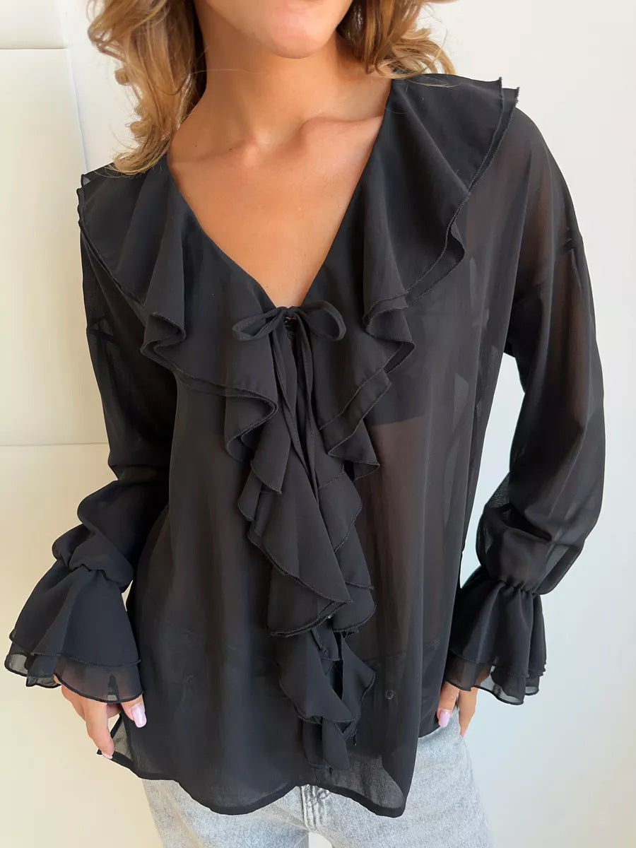 Black ruffle blouse with V-neckline and layered trim details.
