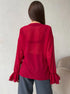 Back view of red sheer blouse with ruffled sleeves