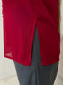 Close-up of red blouse side slit detail over gray pants