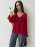 Red ruffle blouse with v-neck styled with gray wide-leg pants