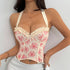 Close-up of ivory embroidered corset top with floral trim and satin skirt.
