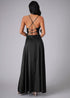 Back view of woman wearing a black dress with criss-cross straps on a gray background