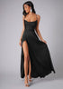 Side view of woman wearing a black satin dress with a high slit.