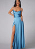 Woman wearing a blizzard blue evening gown with a slit on a gray background