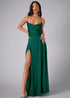 Woman wearing a green evening gown with a high slit on a gray background