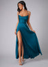 Side view of woman wearing a haze blue dress with a high slit on a gray background