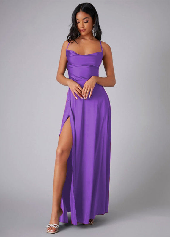 Woman wearing a purple prom dress with a slit on a gray background