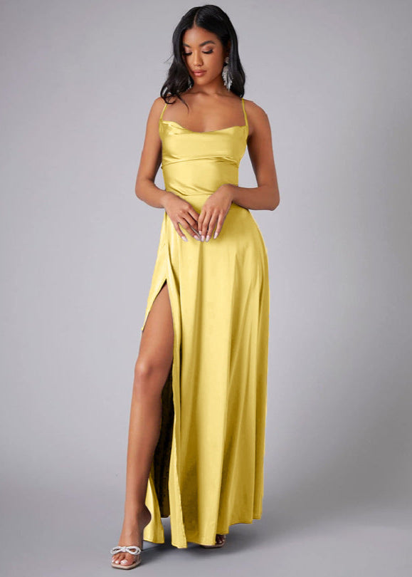 Woman wearing a yellow evening gown with a slit on a gray background