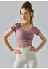 Oriental pink short sleeve yoga top with cropped silhouette and sculpting pleats.