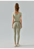 Back view of sisal yoga top with fitted sleeves and wide scoop neck.