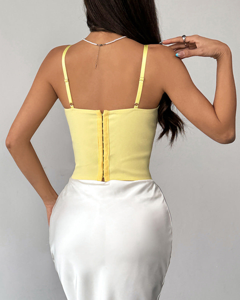 Back view of yellow corset top with hook-and-eye closure and white satin skirt.